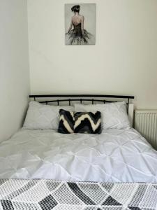 a bed with two pillows and a picture on the wall at Coventry City House - Room 2 in Coventry