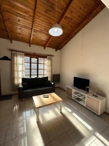 een woonkamer met een bank en een salontafel bij Dúplex centrico in San Martín de los Andes