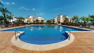 a large swimming pool with buildings in the background at Casa Ortosa C-Murcia Holiday Rentals Property in Baños y Mendigo