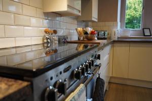 a kitchen with a stove and a counter top at The Old Police House- Beautiful Oxfordshire Countryside Retreat- Sleeps 10 in Bicester