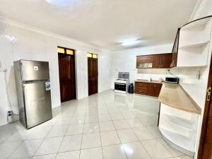 a large kitchen with a stainless steel refrigerator at Burka Serene Home in Arusha