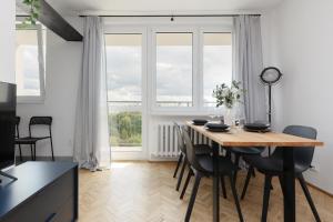 a dining room with a table and chairs and a large window at Family Apartment near Old Town by Renters in Warsaw
