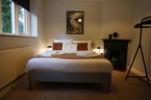 a bedroom with a large bed with a fireplace at The Old Police House- Beautiful Oxfordshire Countryside Retreat- Sleeps 10 in Bicester