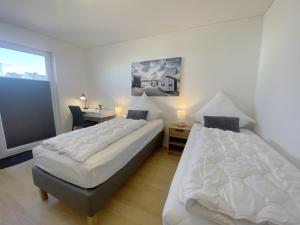 - une chambre avec 2 lits, un bureau et une fenêtre dans l'établissement Sternenmeer, à Olpenitz