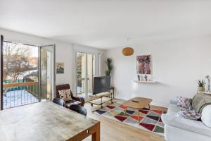 ein Wohnzimmer mit einem Sofa und einem Tisch in der Unterkunft Villa Botanique - Maison avec jardin in Villers-lès-Nancy