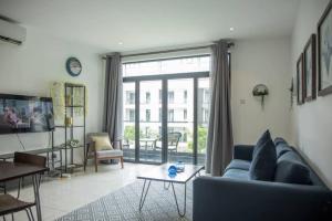 a living room with a couch and a table at Cosy 1 Bedroom @Embassy Gardens in Cantonments