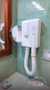 un baño con una manguera blanca pegada a un urinario en Il Barbacane, en Bacoli