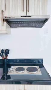 a stove top with a hood in a kitchen at Urban oasis40 in Talisay