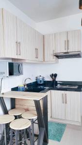 a kitchen with wooden cabinets and a counter with stools at Urban oasis40 in Talisay