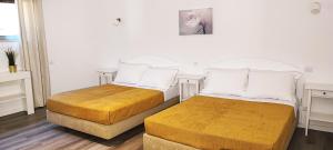two beds in a room with white walls and wooden floors at 6 Bedroom Private Villa Tenazinha I, with private pool in Albufeira