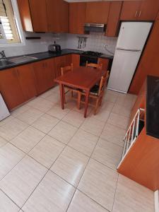 eine Küche mit einem Holztisch und einem Kühlschrank in der Unterkunft Oroklini Hideaway in Oroklini