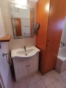 uma casa de banho com um lavatório, um espelho e uma banheira em Oroklini Hideaway em Voroklini