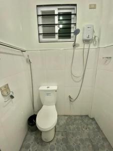 a small bathroom with a toilet and a window at JL Valley Suites in Cauayan City