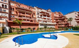 an apartment with a swimming pool in front of a building at Duquesa Regent 2435 Wonderful seaviews duplex in Manilva