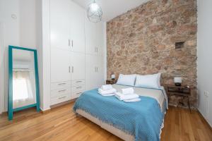 een slaapkamer met een bed en een stenen muur bij CONTEMPORARY APARTMENT 200M FROM ACROPOLIS 100Mbps NETFLIX in Athene