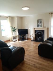 a living room with a couch and a fireplace at Elm Park Escape - 4 bed self-catering holiday home in Buncrana