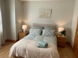 a bedroom with a bed with two lamps and a bedspread at Elm Park Escape - 4 bed self-catering holiday home in Buncrana
