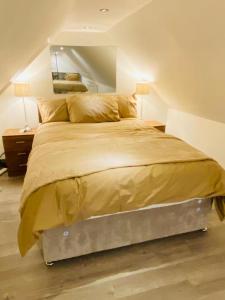 um quarto com uma cama grande num sótão em ABRIDGE PANORAMIC House em Theydon Bois