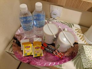 uma mesa com duas garrafas de água e snacks em SCC Gateway Chinatown Hotel em Kuala Lumpur