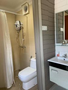 a bathroom with a toilet and a sink and a shower at Casa Tanjung Jara in Dungun