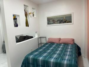 um quarto com uma cama com um cobertor xadrez em Fioravante's Apartment 2 no Rio de Janeiro