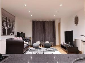 a living room with a couch and a television at Entire Lovely 2 Bedroom Apartment in Southend-on-Sea
