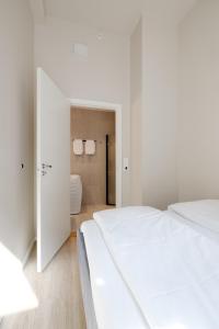 a bedroom with a large white bed and a doorway at Maya Apartments - Parkveien in Oslo