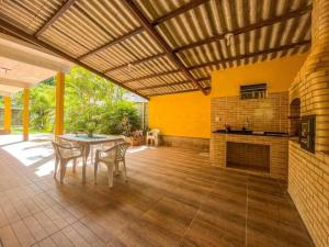 un patio con mesa, sillas y chimenea en Casa com churrasqueira e piscina, perto de riacho en Angra dos Reis