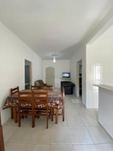 a dining room and living room with a table and chairs at CASA UBATUBA-MARANDUBA, casa térrea in Ubatuba