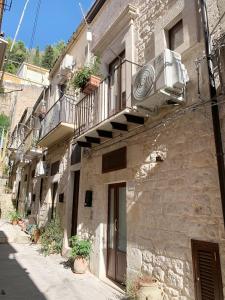 a stone building with a balcony and a door at IL RIFUGIO BAROCCO in Modica