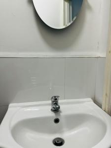 a white sink with a mirror on the wall at Coventry City House - Room 3 in Coventry