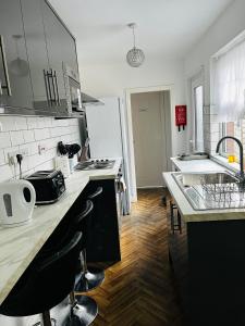 a kitchen with a sink and a refrigerator at Coventry City House - Room 3 in Coventry