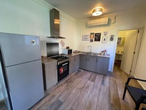 a kitchen with a refrigerator and a stove top oven at Batroun chalet in front of the pool - Batrouna Park Resort 