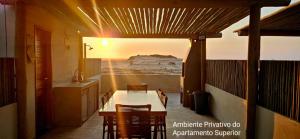 a dining room with a table and chairs with a desert view at Condominio Boas Vistas in Aracati