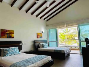 1 dormitorio con 2 camas y ventana grande en ¡Fantastic Beach House!, en Arroyo de Piedra