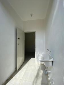 a white bathroom with a sink and a hallway at CASA UBATUBA-MARANDUBA, casa térrea in Ubatuba