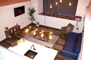 a living room with a table and a blue chair at Heated Floors, High Ceiling, Open Plan, Cosy, Modern, Stylish Sheffield City Centre in Sheffield