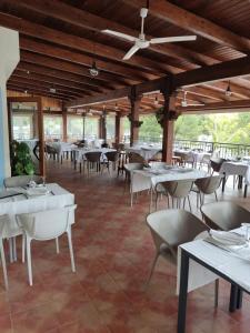 uma sala de jantar com mesas e cadeiras brancas em El retiro hotel rural em Moratalla