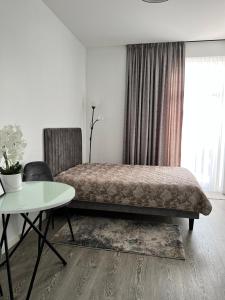 - une chambre avec un lit, une table et un bureau dans l'établissement Arena apartment, à Kaunas