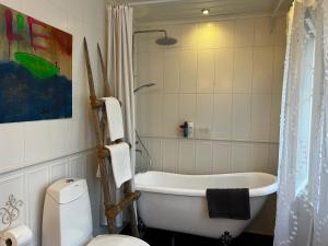 a bathroom with a tub and a toilet and a sink at Moonloft@VillaSolbacka in Inkoo +37 photos