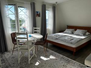 a bedroom with a bed and a table and chairs at Moonloft@VillaSolbacka in Inkoo