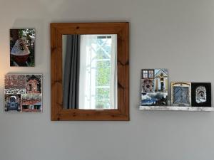 a mirror on a wall with pictures on it at Moonloft@VillaSolbacka in Inkoo