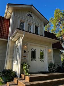a house with a white door and a porch at Moonloft@VillaSolbacka in Inkoo