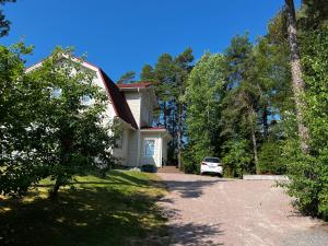 a white house with a car parked in the driveway at Moonloft@VillaSolbacka in Inkoo