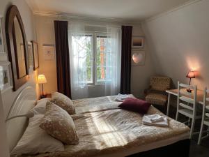 a bedroom with a bed with pillows and a window at Moonloft@VillaSolbacka in Inkoo