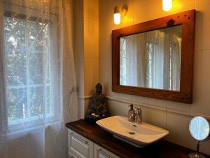 a bathroom with a sink and a mirror and a window at Moonloft@VillaSolbacka in Inkoo