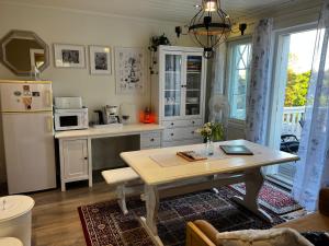 uma cozinha com uma mesa e um frigorífico branco em Moonloft@VillaSolbacka em Inkoo