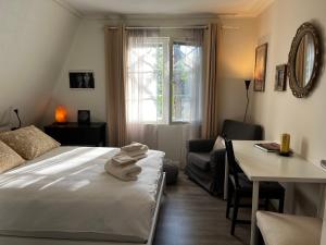 a bedroom with a bed and a desk and a table at Moonloft@VillaSolbacka in Inkoo
