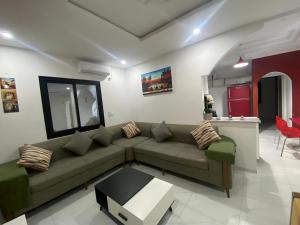 Awlād ‘Umar的住宿－Villa Maria & Nour，客厅配有绿色沙发和桌子