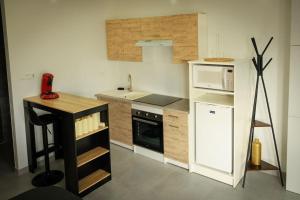 a kitchen with a white refrigerator and a microwave at Le Gîte Cookie in Urschenheim